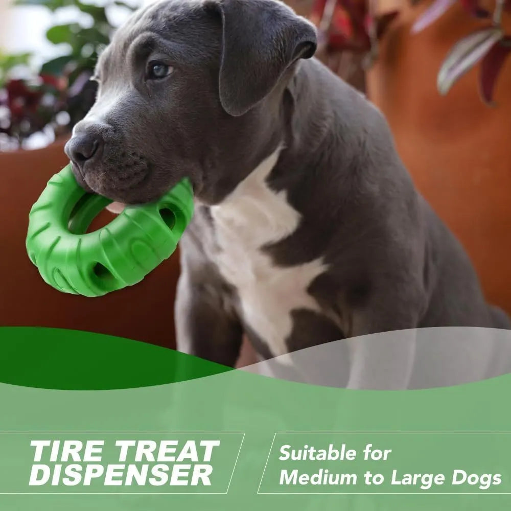 Blue rubber tyre-shaped dog chew toy and slow feeder with oval openings on a wooden floor.