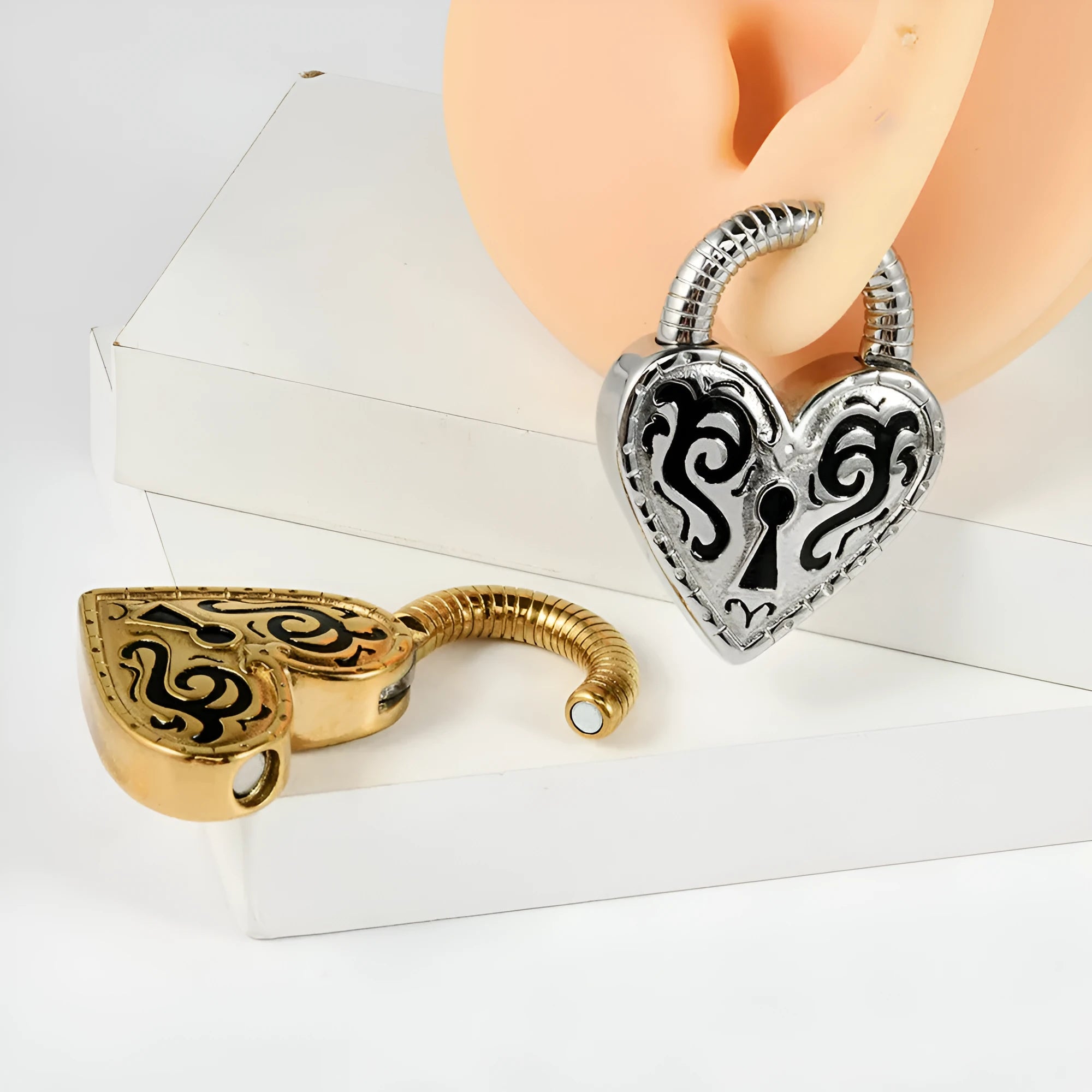 Close-up of a women's stainless steel heart-shaped earring for piercings, shown in gold and steel colour options.