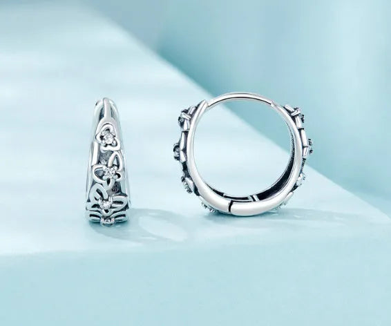 Sterling silver retro hollow butterfly earrings with zircon accents on a white background.