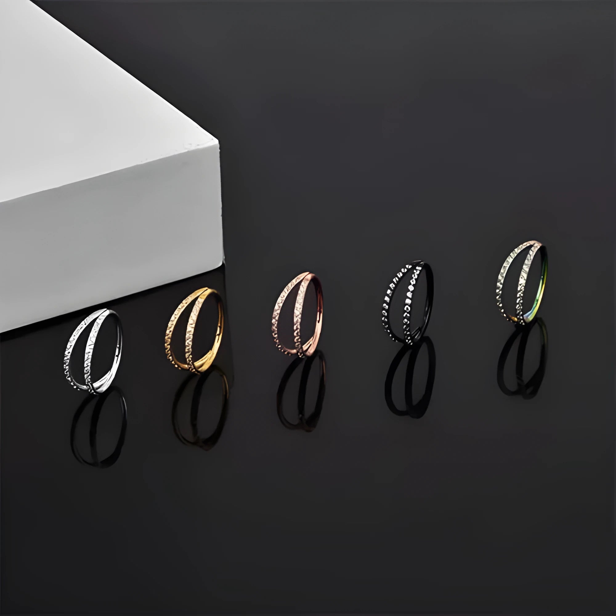 G23 titanium alloy lip ring and nose ring in gold and steel colour on a white background.