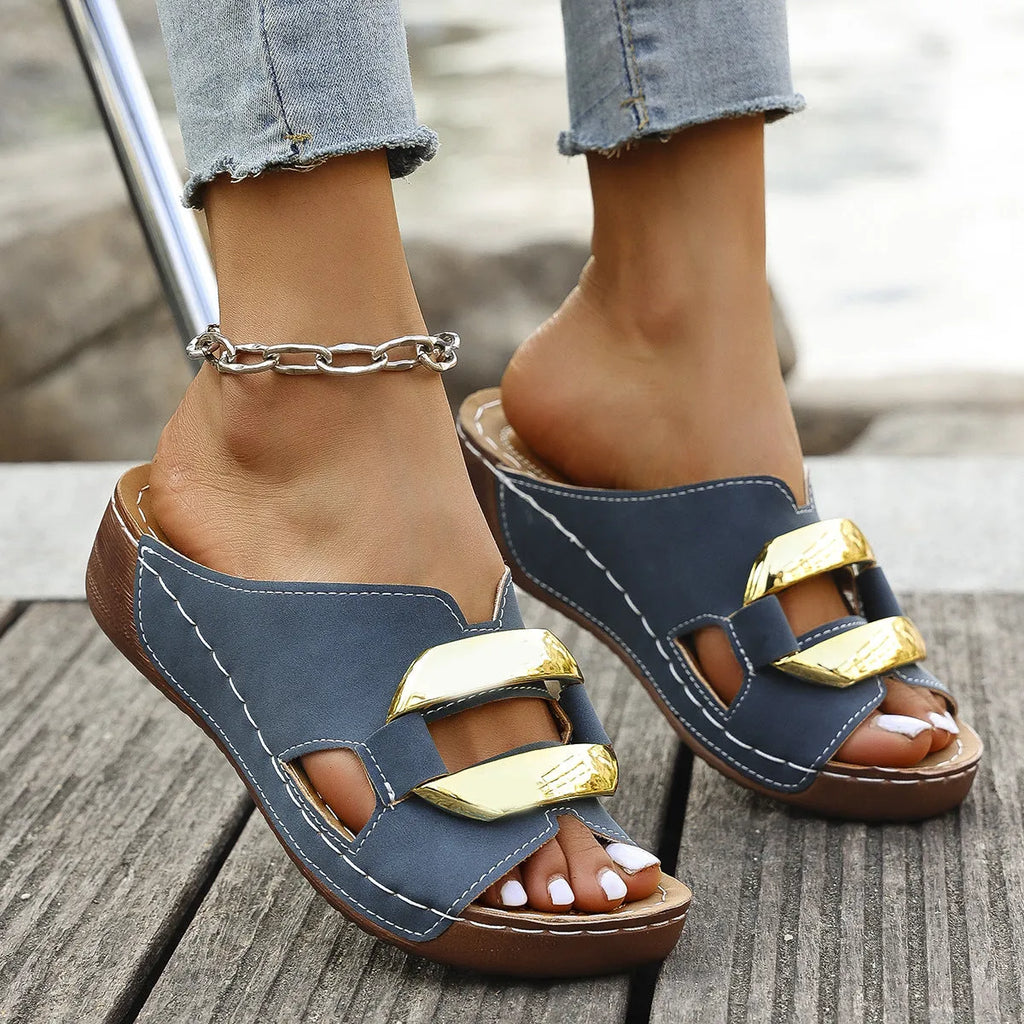 Roman style flat platform sandals in white, black, khaki, and sea blue with a metal detail and rubber sole.