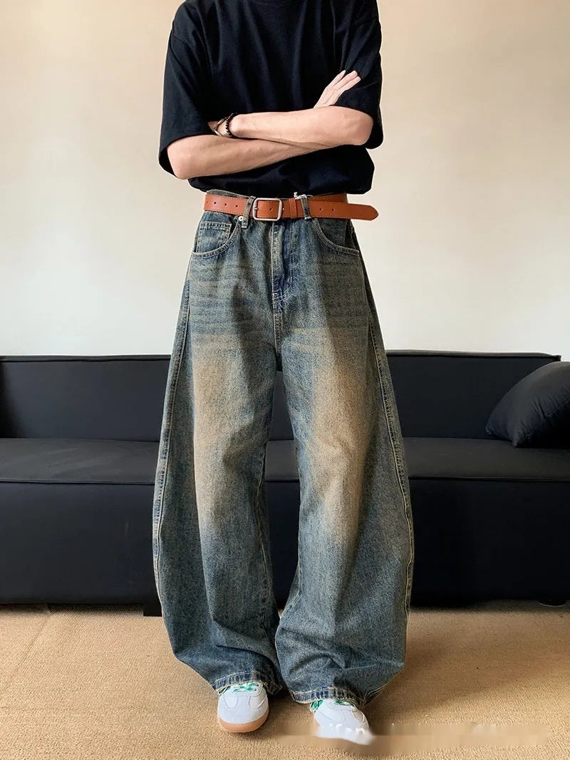Men's distressed retro blue denim trousers with wide-leg silhouette and micro-elastic cotton-blend fabric