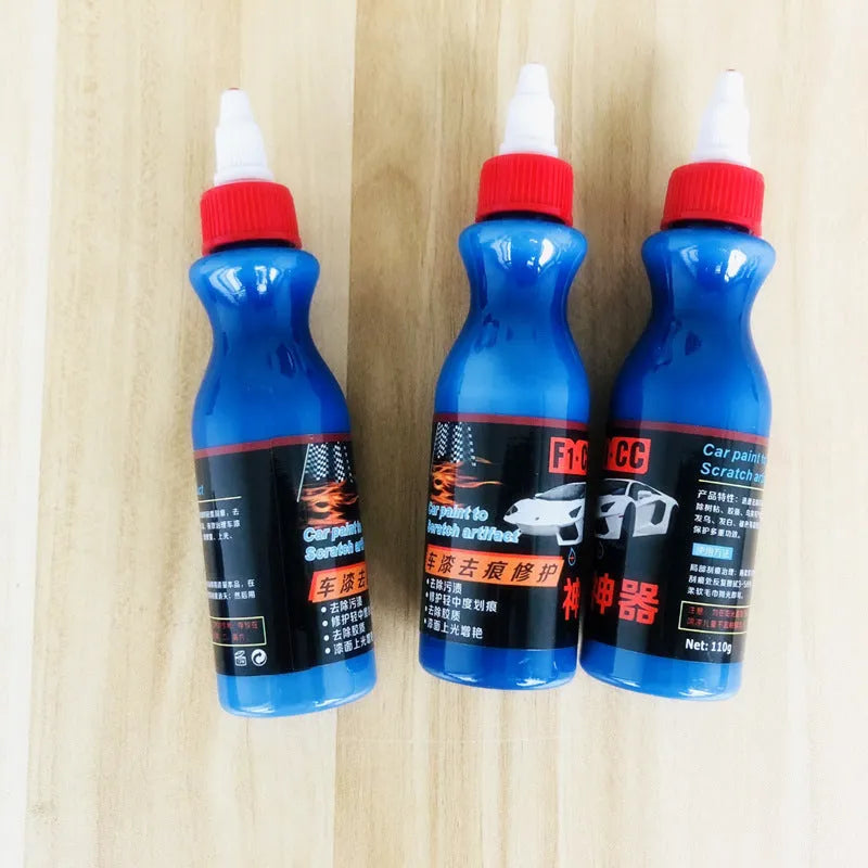 Small blue car wiping tool and bottle of scratch repair agent for DIY automotive scratch removal.