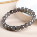 Smokey violet Hetian jade straight cut beaded bracelet on a wrist.