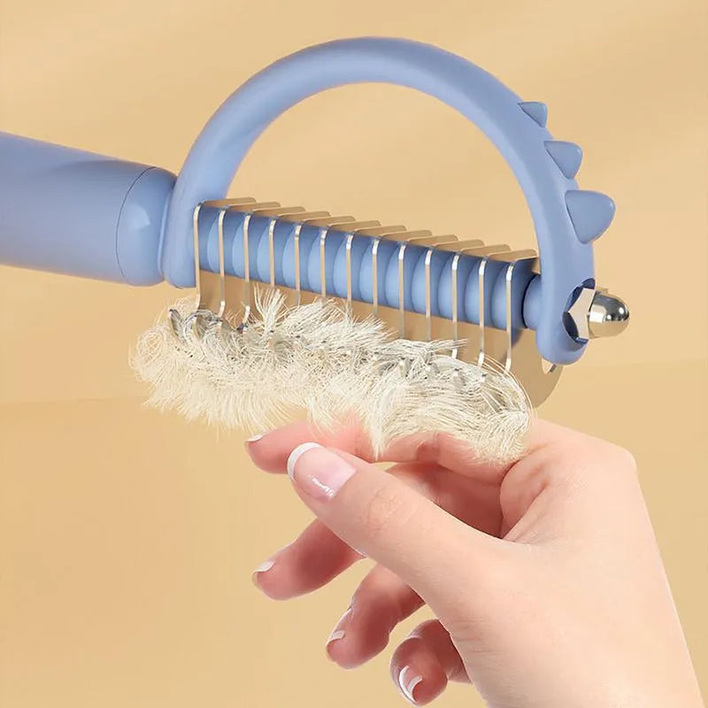 Blue dinosaur-shaped cat brush with stainless steel pins for self-cleaning grooming and dematting