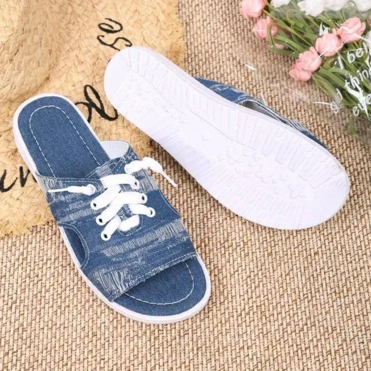Blue women's flat canvas Roman style slippers with cloth upper and rubber sole.