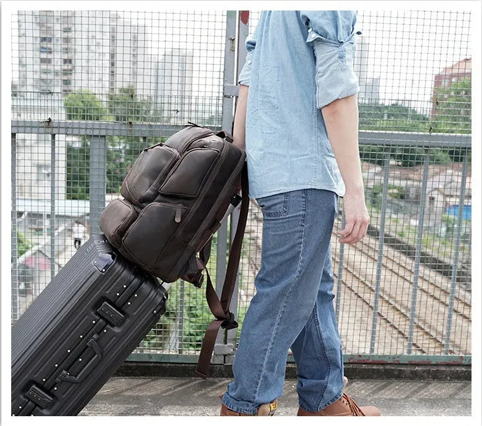 Dark brown genuine leather 17-inch laptop backpack with double straps and multiple pockets.
