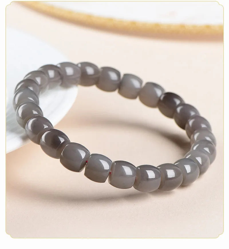 Smokey violet Hetian jade straight cut beaded bracelet on a wrist.