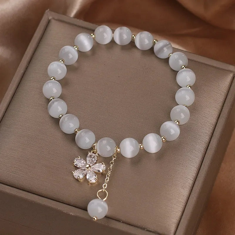 White cat's eye crystal bracelet with flower tassels and morganite safety buckle pendant.