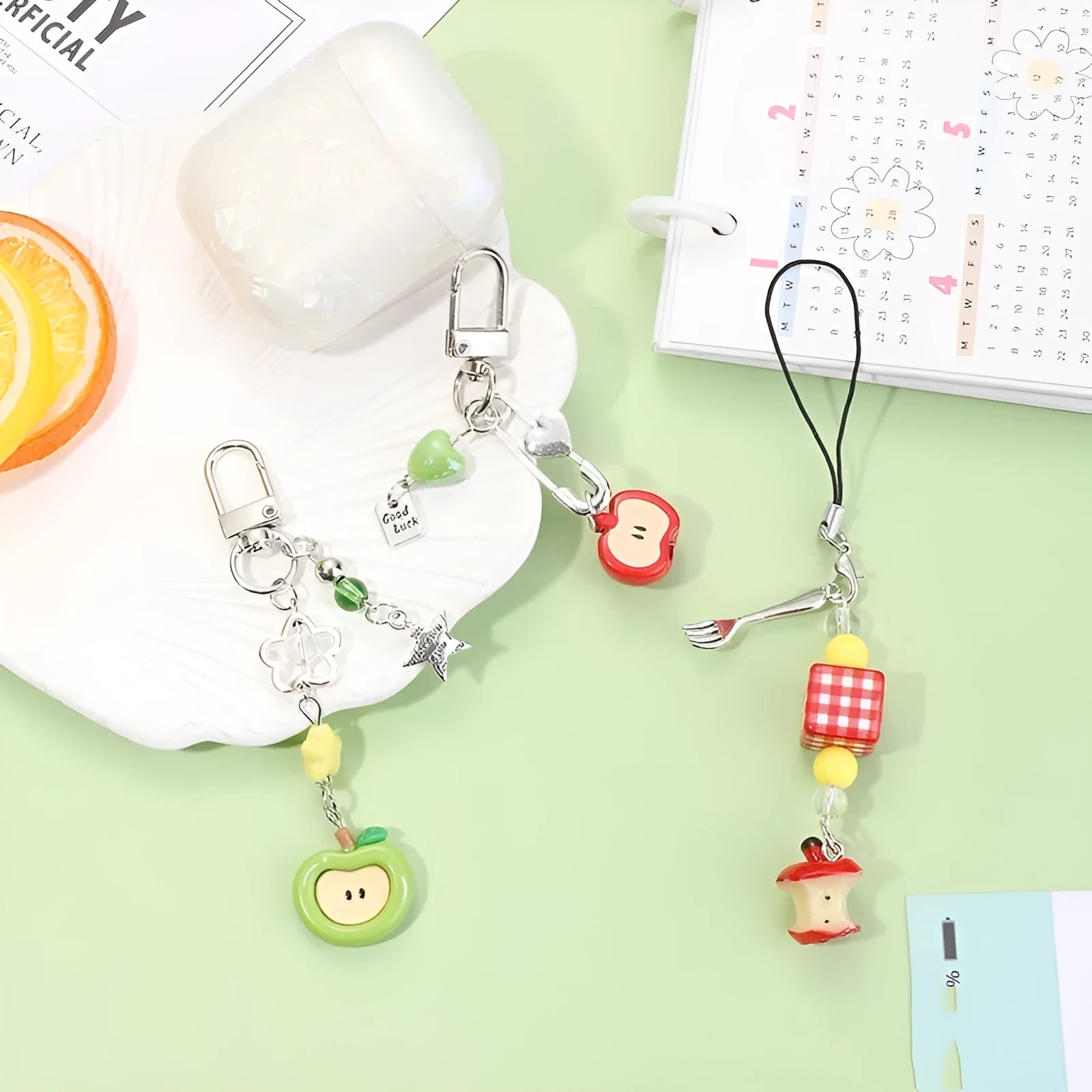 Coloured plastic fruit phone charms with rope attachments including apple and strawberry designs