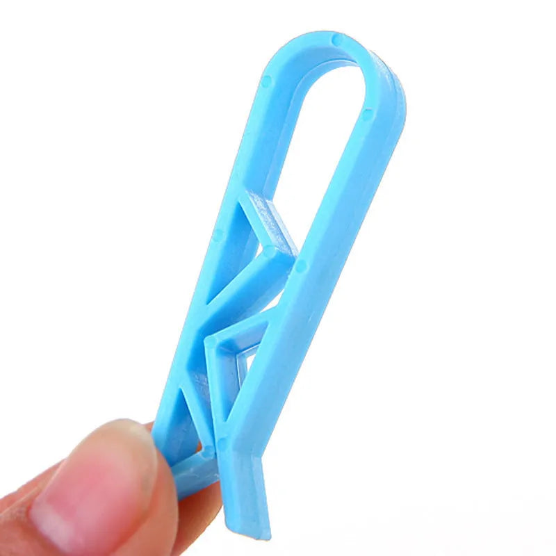 A white polypropylene plastic clip for holding bin bags onto the side of a rubbish bin.