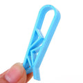 A white polypropylene plastic clip for holding bin bags onto the side of a rubbish bin.