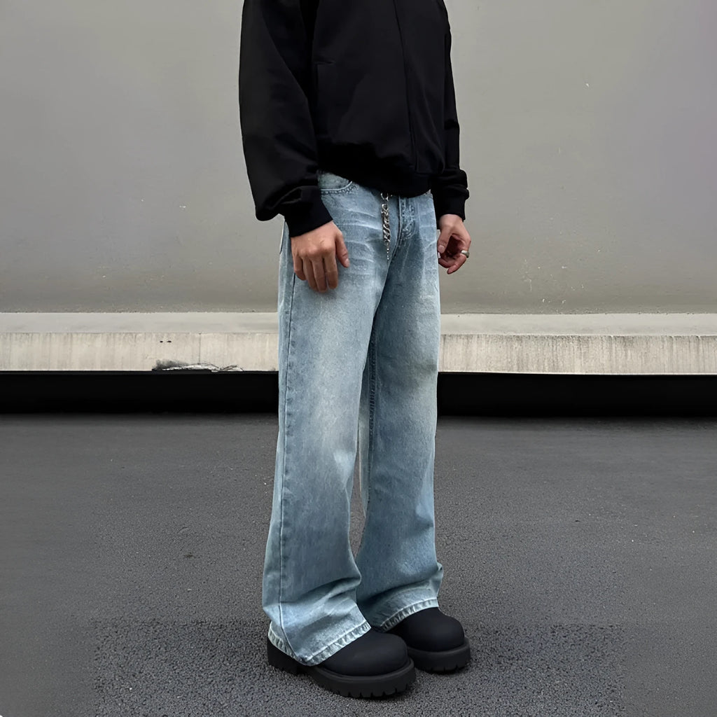 Men's blue straight-leg denim jeans with a whisker wash effect, showing a flared leg and visible stitching detail.