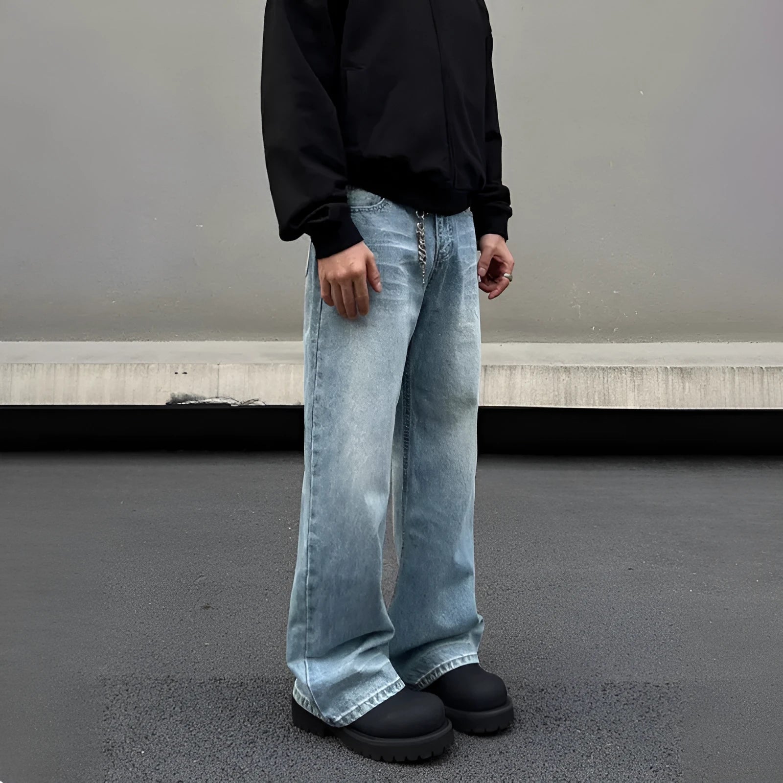 Men's blue straight-leg denim jeans with a whisker wash effect, showing a flared leg and visible stitching detail.