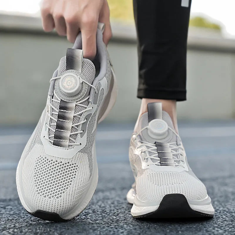Men's white low-top running shoes with a rotating button buckle and round toe on a gray background.