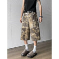 Yellow women's cropped jeans with a bold snake and camouflage pattern print on the legs.