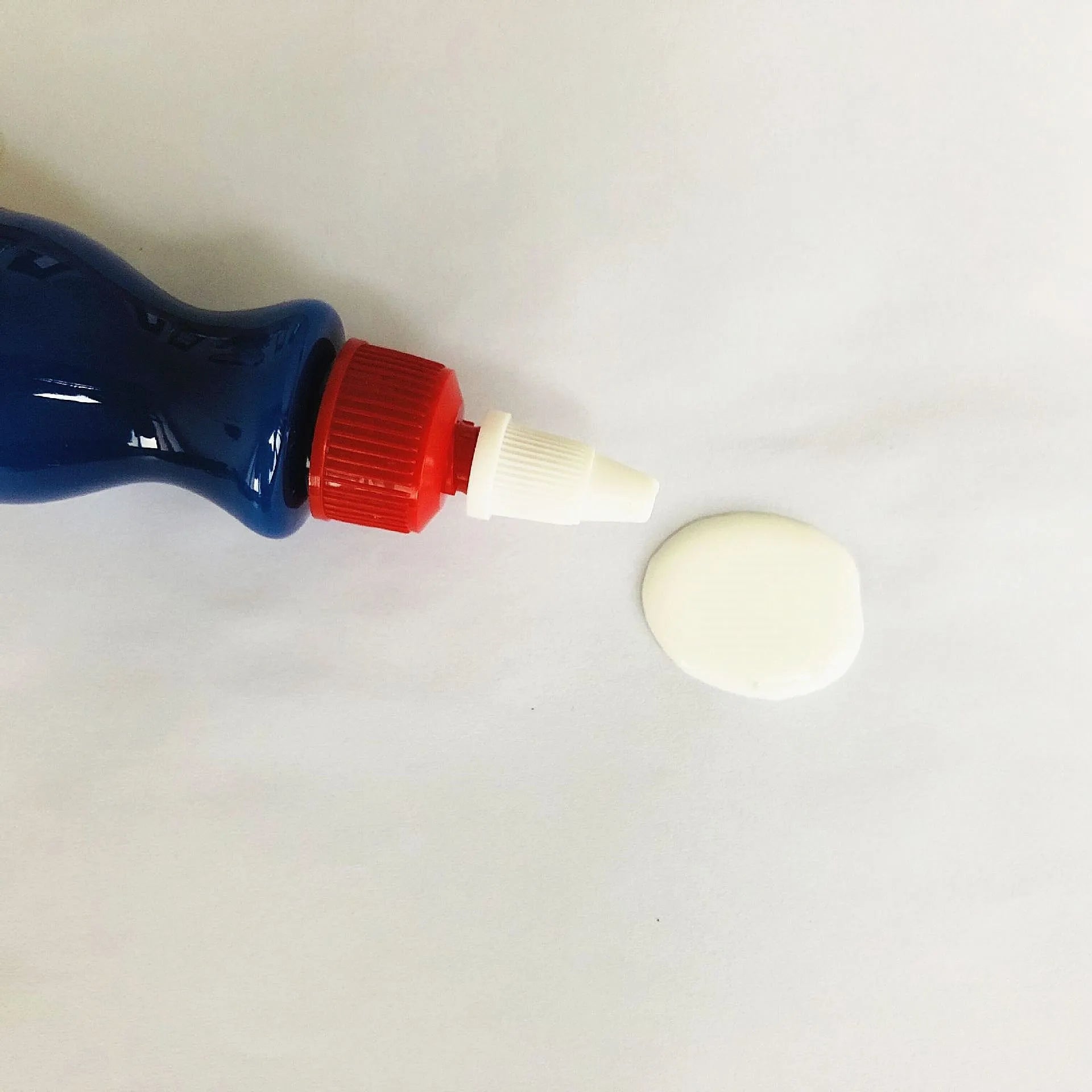 Small blue car wiping tool and bottle of scratch repair agent for DIY automotive scratch removal.