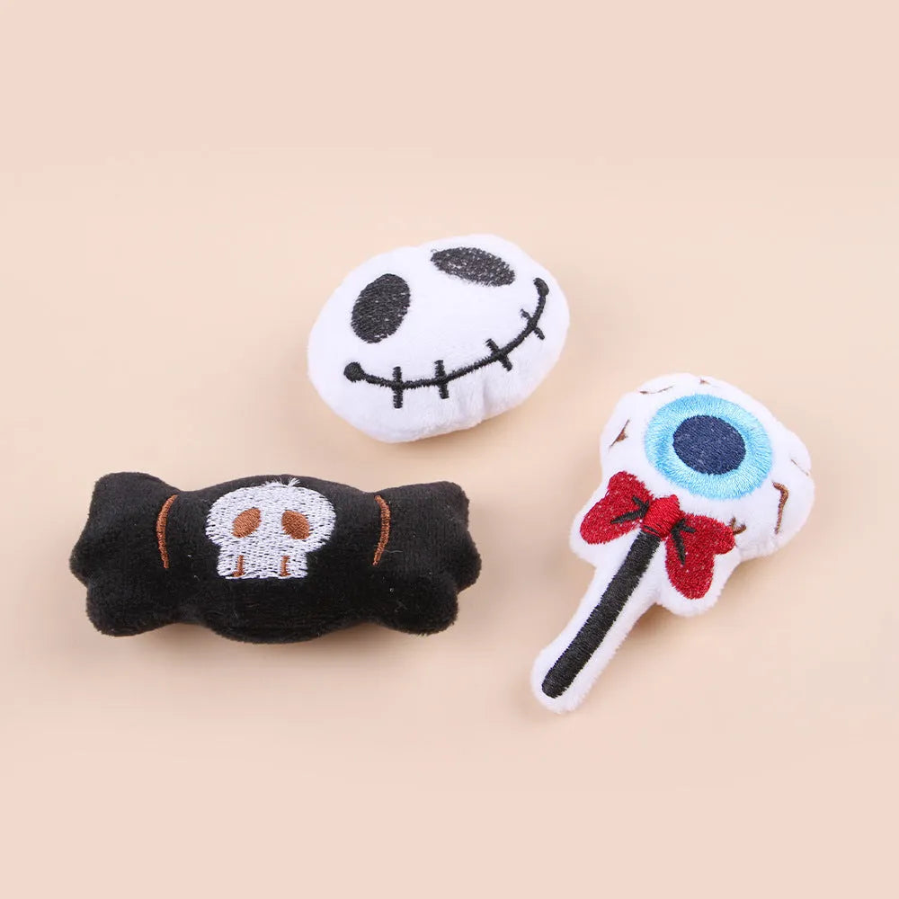 Small plush cat teaser wand toy showing candy, skull and eye patterns on soft fabric