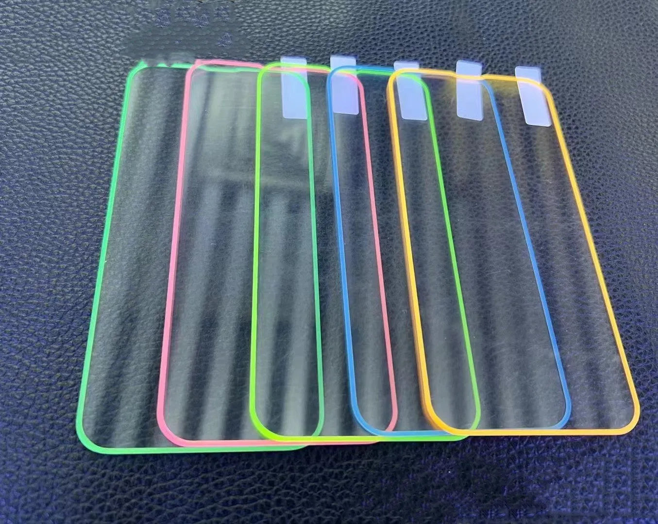 Fluorescent luminous tempered glass screen protector for iPhone on a phone.