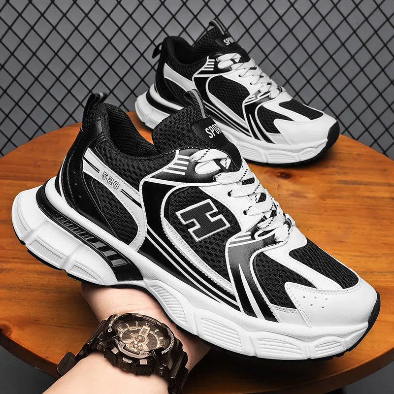 Men's solid colour mesh running shoes with a plastic sole, shown in black, white and grey, and white and orange.