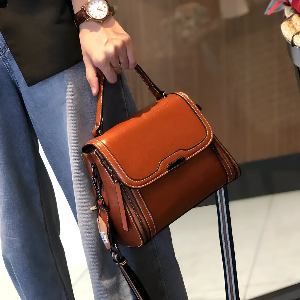 Genuine leather women's retro messenger bag in brown, showing internal organiser pockets and shoulder strap.
