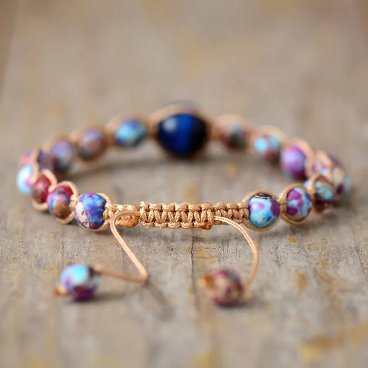 Hand woven adjustable friendship bracelet with a grey Emperor Stone centrepiece on a neutral background