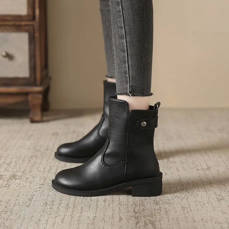 Black women's low heel ankle boots with side zip and round toe on a rubber sole.