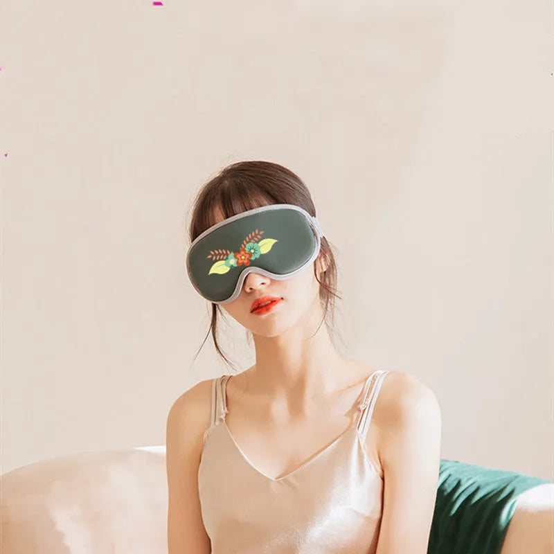 Pink and green portable eye spa mask with USB cable for steam heat and vibration massage.