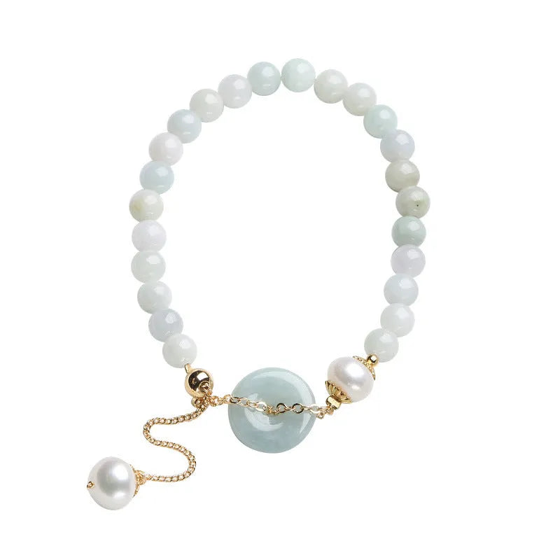 Natural emerald green jade round pendant on a women's bracelet with a geometric peace buckle.