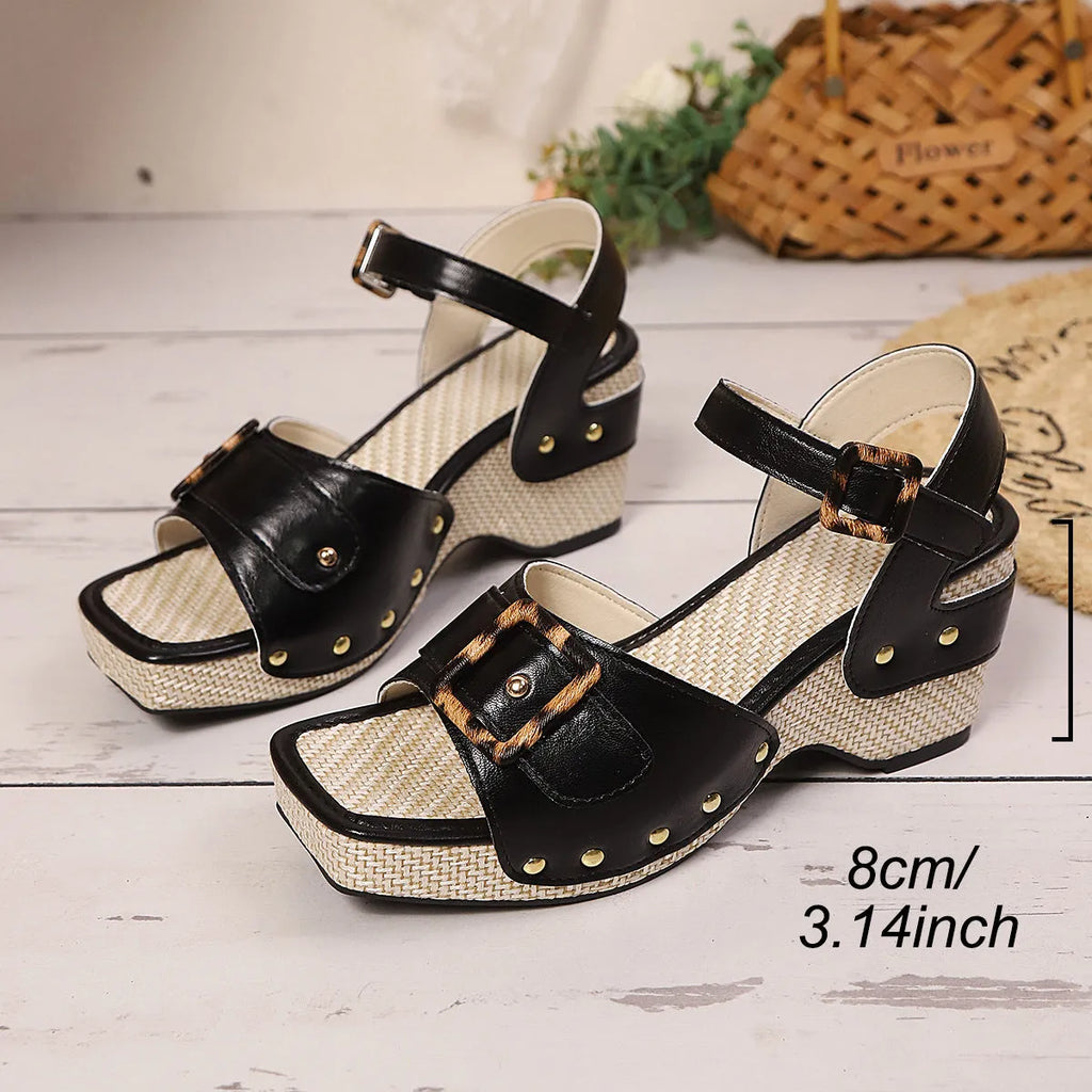 Women's black square-toe sandals with a chunky heel and metal buckle fastening on a white background.