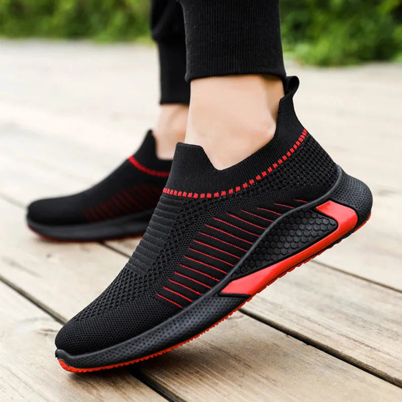 Men's black and white striped mesh slip-on sneakers with lace-up front on a plain background.