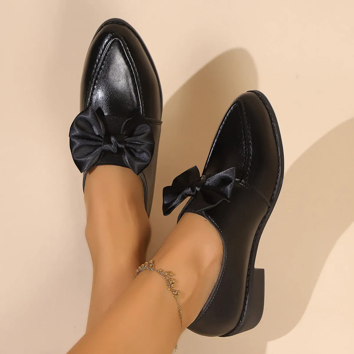Women's brown PU leather slip-on shoe with a large bow on the pointed toe.