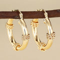 Golden geometric earrings with ring and line design elements on copper