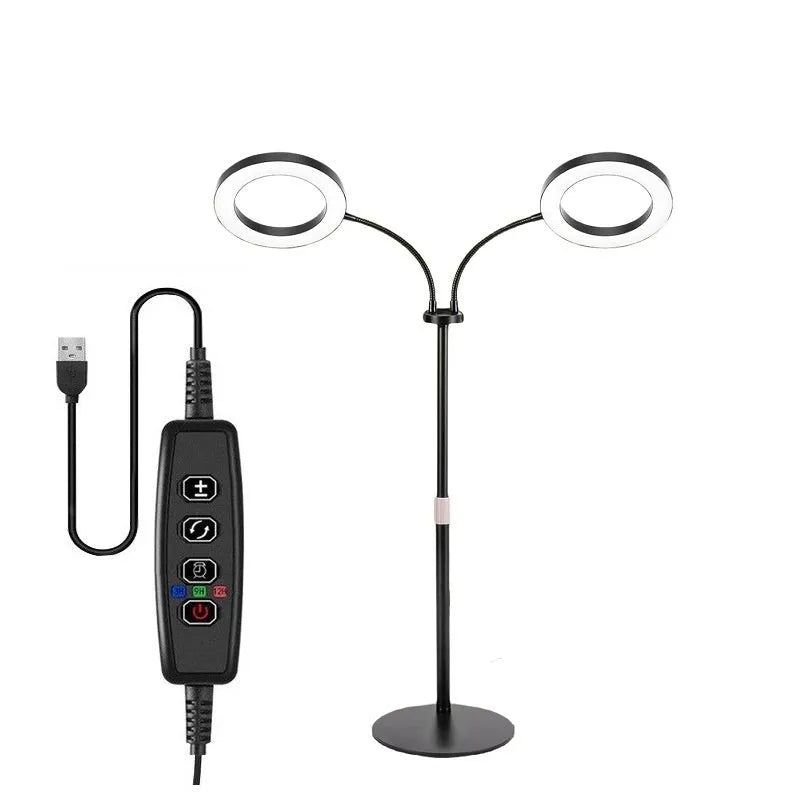 A tall, retractable aluminium floor stand with a 6-inch ring LED plant grow light at the top, positioned next to indoor houseplants.