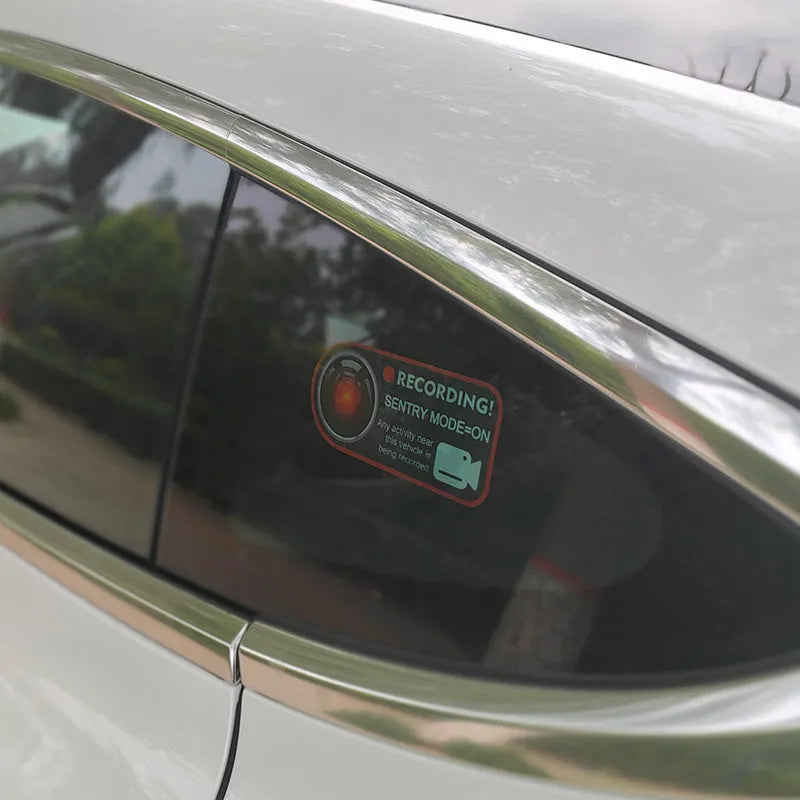 A pair of white and red electrostatic warning stickers for Tesla car windows measuring 11 by 5 cm.