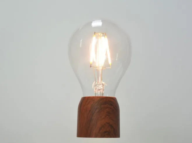 Glass and ABS magnetic levitation bulb floating above an imitation wood base.