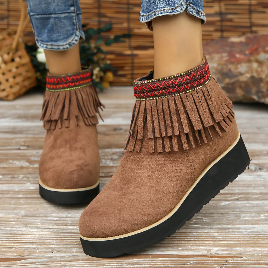 Women's dark brown suede wedge ankle boot with side zipper and tassel detail on a thick rubber sole.