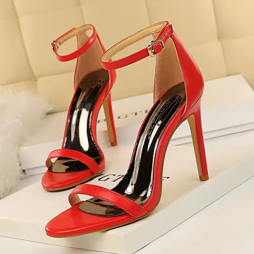 Ankle-strap high heel shoe with open toe and buckle, shown in a solid colour.