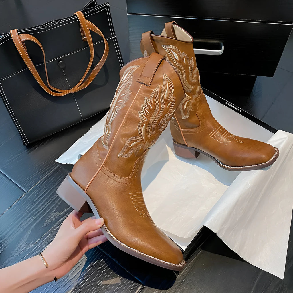 Brown women's mid-calf Martin boots with embroidered detail on the upper and a low square heel.