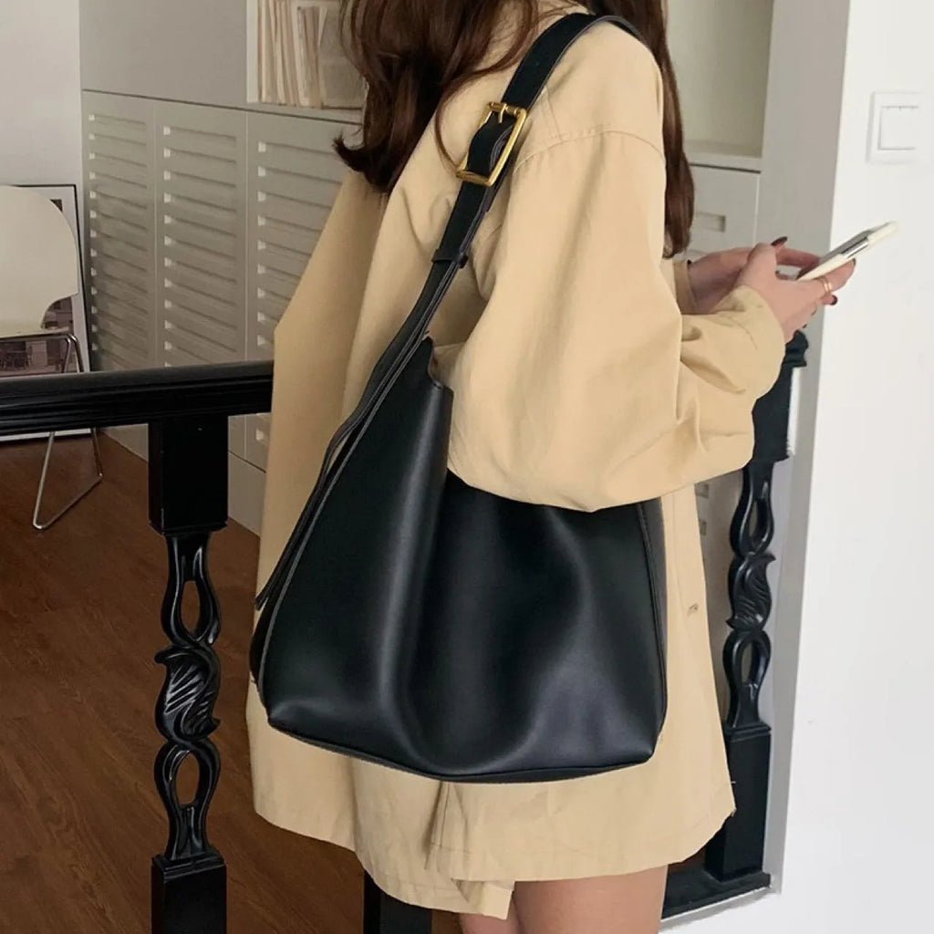 Two women's fashion shoulder bags in black and brown PU leather with swing thread details