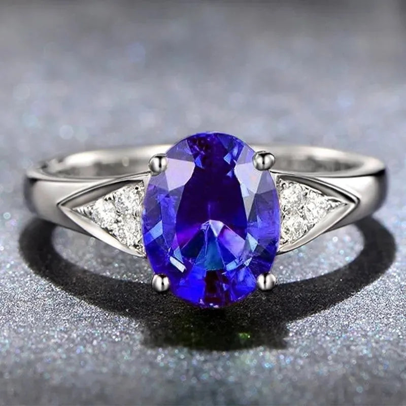 Women's court style ring with inlaid natural zircon stone forming a heart design, on a model's finger.