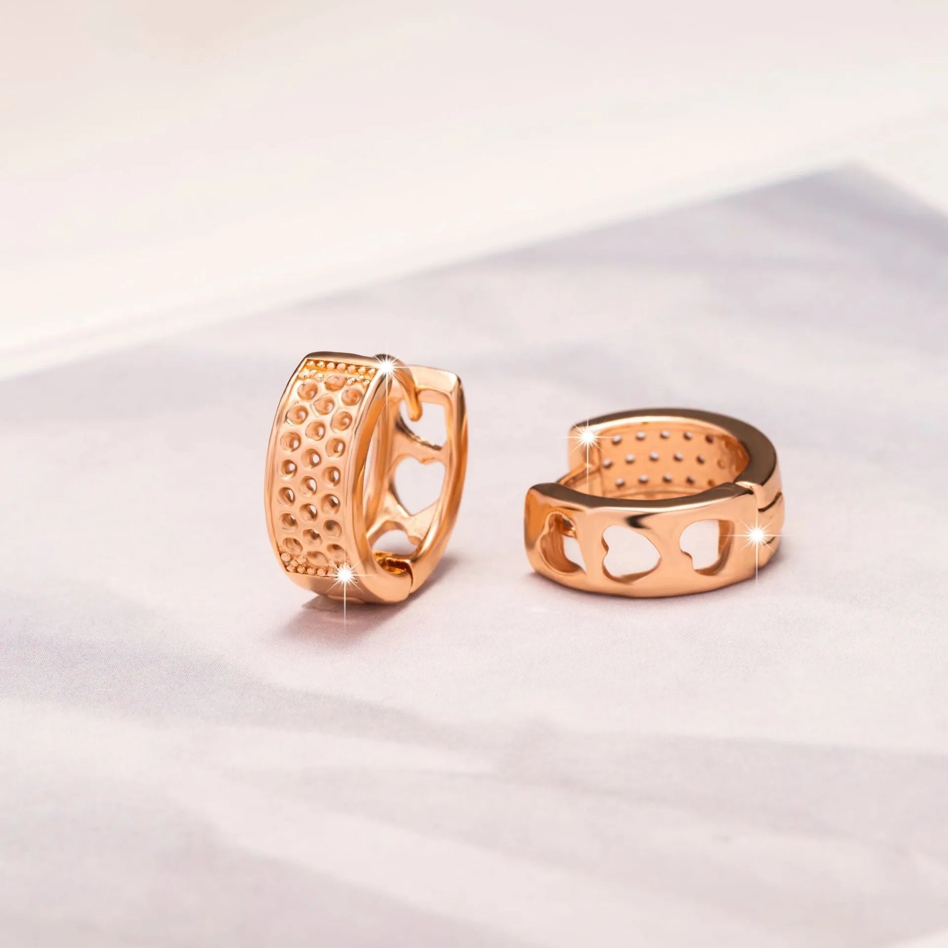Rose gold hollow heart earrings with three open sections and circular shape