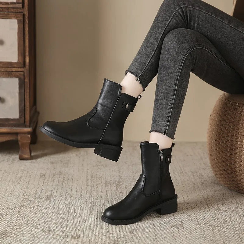 Black women's low heel ankle boots with side zip and round toe on a rubber sole.