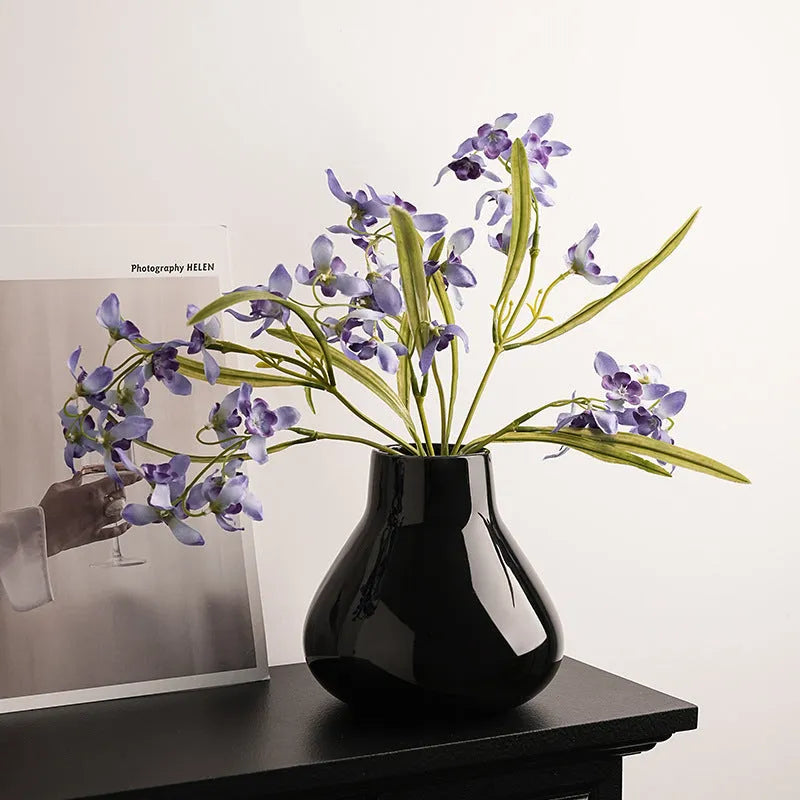 Ceramic round belly decorative vase with coloured glaze and artificial flowers in black or white