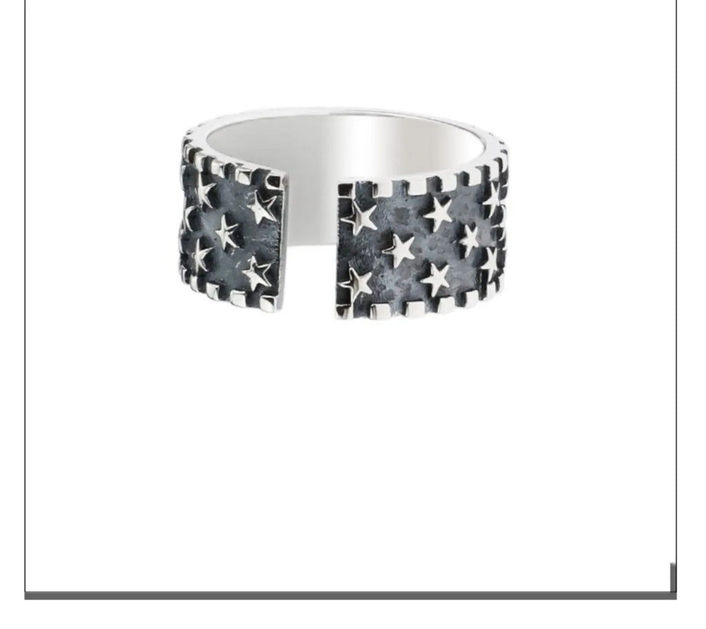 Adjustable opening sterling silver ring with a geometric pattern of several five-pointed stars.