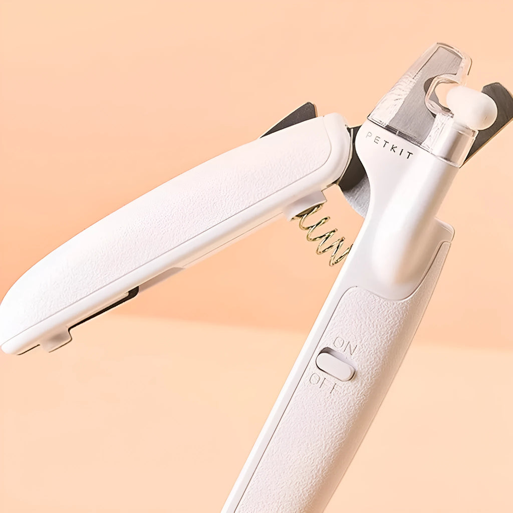 White pet nail clippers with LED light and transparent splash guard open, showing the triangular steel blade.