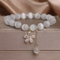 White cat's eye crystal bracelet with flower tassels and morganite safety buckle pendant.