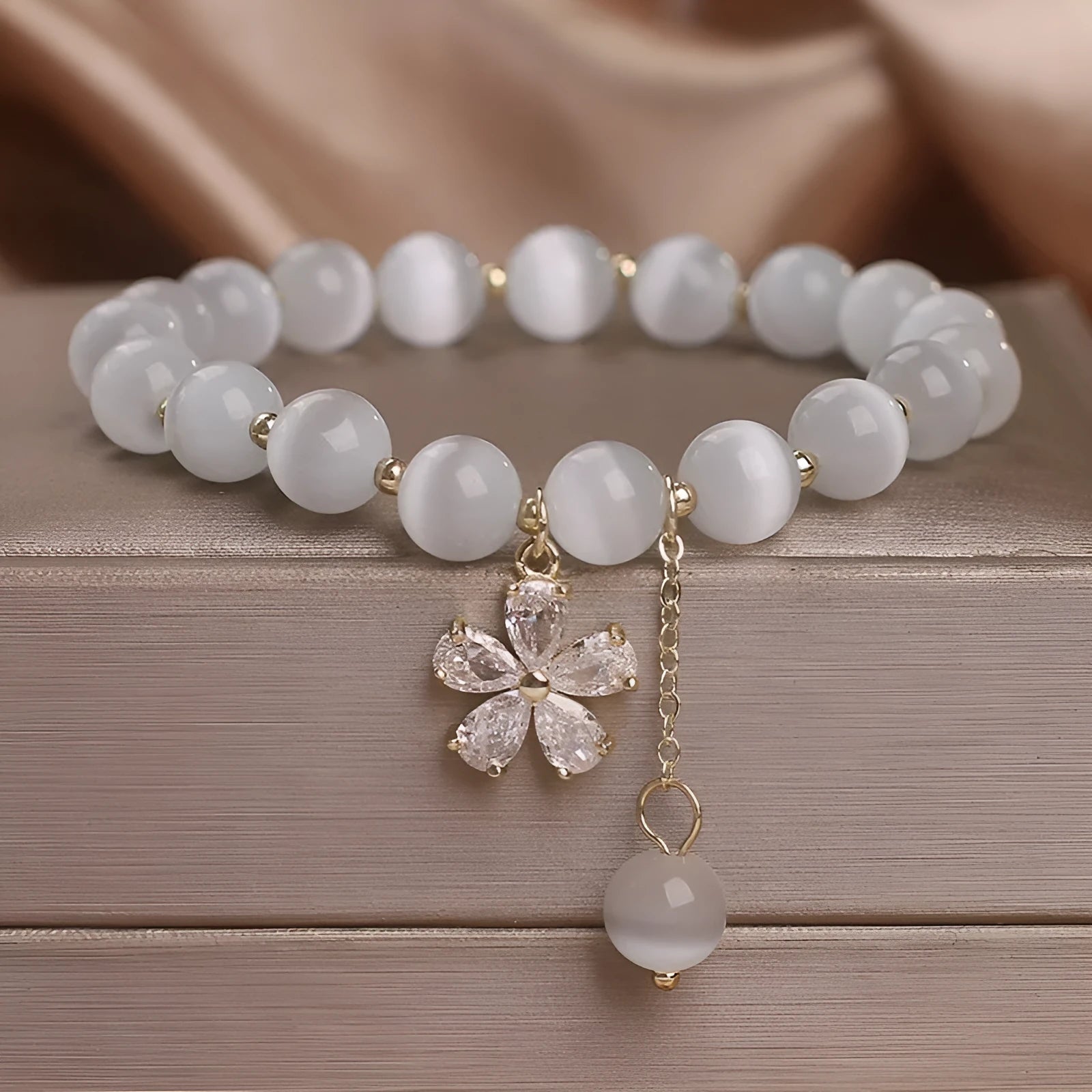 White cat's eye crystal bracelet with flower tassels and morganite safety buckle pendant.