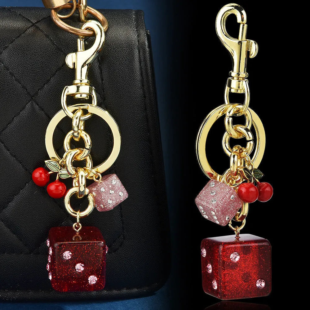 Square metal keychain pendant with cherry two-tone dice pattern and electroplated finish