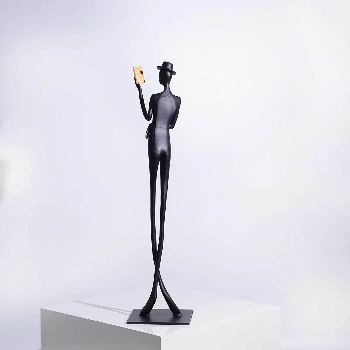Black aluminium desktop sculpture of a woman reading, modern style.